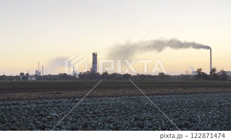 Heavy gray smoke is poured from the chimney pipes of thermal power plant. Carbon dioxide emitting from chimneys from industrial factory into the atmosphere. Concept of environmental pollution problem 122871474