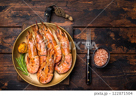 Grilled red Argentine shrimps, Prawns Langostino Austral on a plate with herbs. wooden background. top view 122871504