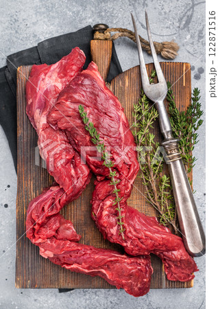 Uncooked Beef Skirt Steak, also name Machete steak, raw meat on cutting board. grey background. top view Uncooked Beef Skirt Steak, also name Machete steak, raw meat on cutting board. grey background. top view 122871516