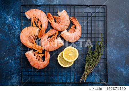 Ready for cooking Headless Red shrimps, raw Prawns on a rack. blue background. top view 122871520