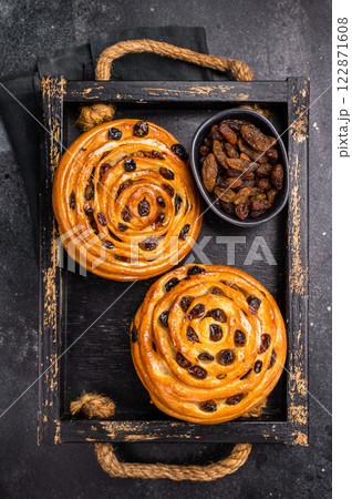 Danish raisin pastry swirls. black background. top view Danish raisin pastry swirls. black background. top view 122871608