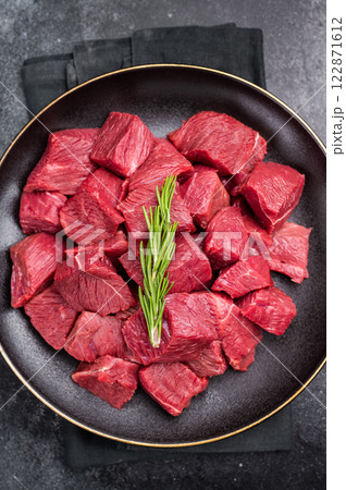 Diced Raw Boar meat, fresh Game Meat in a plate. black background. top view 122871612