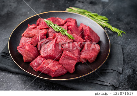Diced Raw Boar meat, fresh Game Meat in a plate. black background. top view 122871617
