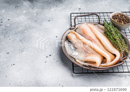 Raw Hake fish fillet in steel tray with herbs. grey background. top view 122871690