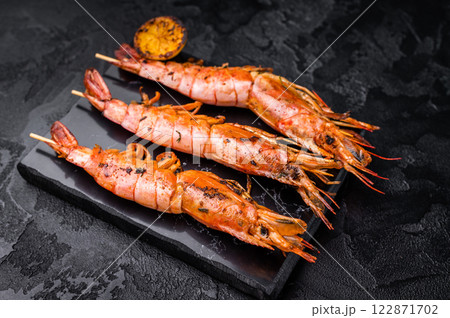 Shrimp kebab, Skewers with Grilled red Prawns Langostino Austral. black background. top view 122871702