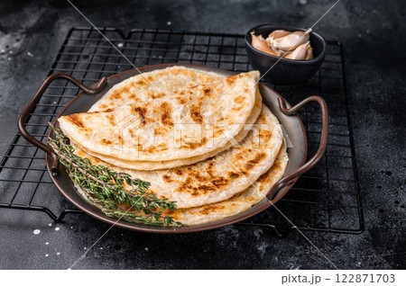 Aloo Paratha Indian Potato stuffed Flatbread. black background. top view Aloo Paratha Indian Potato stuffed Flatbread. black background. top view 122871703