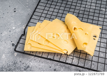 Maasdam cheese slices on kitchen table. grey background. top view 122871789