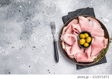 Meat appetizer with Sliced Prosciutto Cotto ham and green olives. grey background. top view Meat appetizer with Sliced Prosciutto Cotto ham and green olives. grey background. top view 122871871
