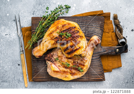 Roast chicken legs with Thigh on wooden cutting board, grilled poultry meat on gray background, top view 122871888