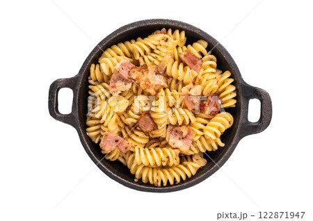 Fusilli delicious carbonara pasta topped with crispy bacon bits and fresh herbs in a skillet isolated on white background Fusilli delicious carbonara pasta topped with crispy bacon bits and fresh herbs in a skillet isolated on white background 122871947