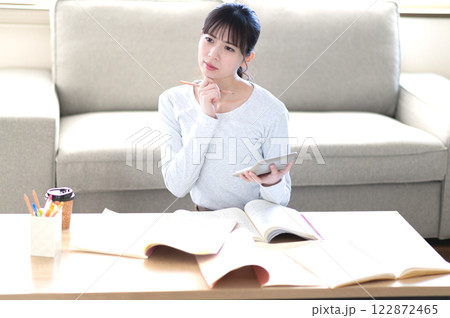 リビングで一人で勉強する若い女性 122872465