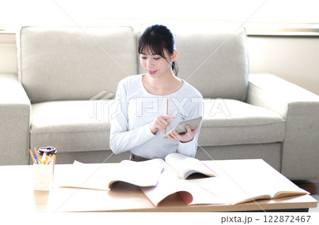 リビングで一人で勉強する若い女性 122872467