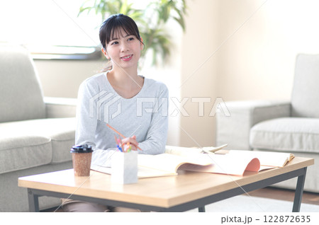 リビングで一人で勉強する若い女性 122872635