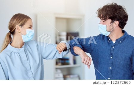 Business team, elbow bump and covid compliance with employees greeting with social distance in an office. Man and woman in the office during coronavirus wearing a face mask and working after lockdown 122872660