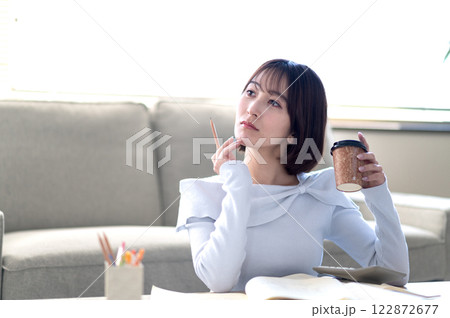 リビングで一人で勉強する若い女性 リビングで一人で勉強する若い女性 122872677