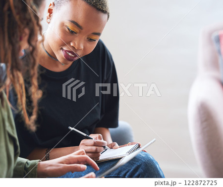 African american woman writing notes with friend showing ideas on digital tablet computer students brainstorming 122872725
