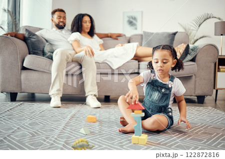 Child, development and toy blocks while learning motor skill and colors while building a tower in lounge at home with parents or adult supervision. Girl kid playing and fun with educational activity 122872816