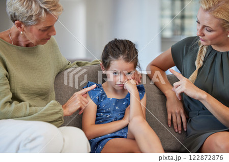 Angry family, discipline and sad children at home for naughty, stubborn and bad behavior problem. Moody girl kid with adhd, fear and anxiety in conflict fight with frustrated mother and anger grandma 122872876