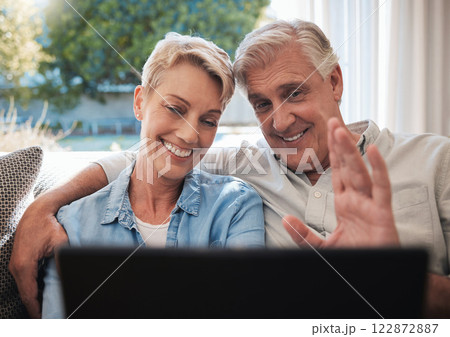 Senior couple, laptop and video call greeting in living room talking, communication and speaking on sofa at house. Elderly, love and retirement man and woman on family home pc wifi video conference 122872887