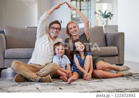 Family home with parents, kids and roof sign for real estate, moving house property and life insurance policy, cover and support. Portrait of mom, dad and rooftop over children in lounge for security 122872892