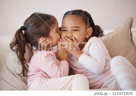 Girl, friends or children whisper secret to best friend on home sofa while relax together on play date. Communication, conversation and sisters or youth kids gossip at fun slumber party or sleepover 122872920