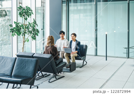 広々としたオフィスビルのエントランスで商談をするビジネスパーソン 122872994
