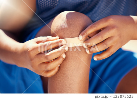 Children, accident and plaster with a band aid on the knee of boy with an injury, wound or pain. Kids, cut and heal with the hands of a male child outside with a scrape, bruise or injured anatomy Children, accident and plaster with a band aid on the knee of boy with an injury, wound or pain. Kids, cut and heal with the hands of a male child outside with a scrape, bruise or injured anatomy 122873523