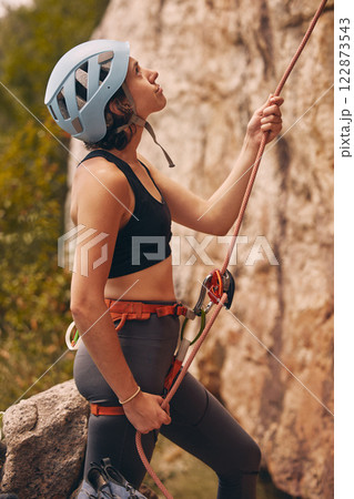 Rope, rock climber and woman mountain climbing in nature for exercise, endurance and body training outdoors. Fitness, challenge and fearless girl ready to climb a rocky cliff on a dangerous adventure 122873543