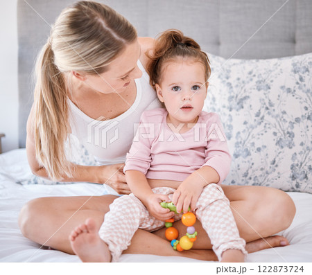 Portrait of girl with mother in bedroom in home, bonding and playing while holding toy. Love, family and caring happy woman with little kid, child or toddler spending free time together in the house Portrait of girl with mother in bedroom in home, bonding and playing while holding toy. Love, family and caring happy woman with little kid, child or toddler spending free time together in the house 122873724