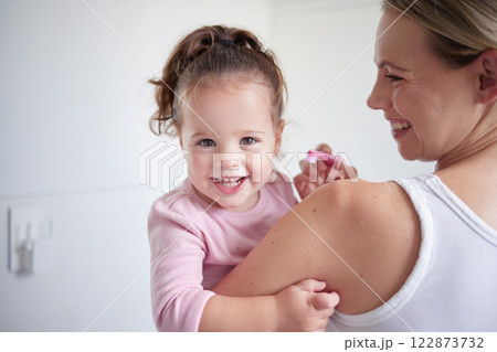 Mother teaching happy girl dental hygiene, baby toothbrush and mom holding kid. Clean teeth, home healthcare and portrait of child growth. Laugh in children bathroom, healthy mouth and natural smile 122873732