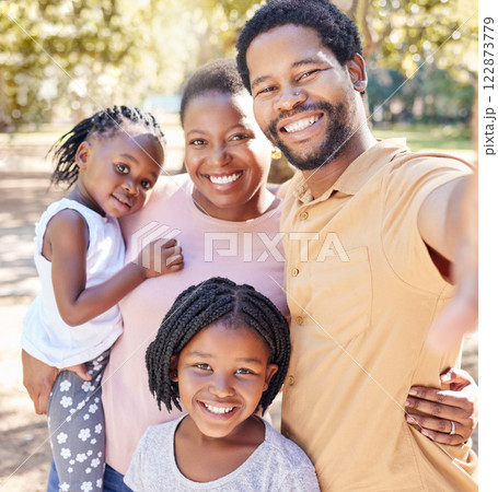 Happy black family take a selfie in nature on a holiday vacation trip together enjoy quality time at a kids park. Smile, happiness and African girls love taking pictures with their mother and father Happy black family take a selfie in nature on a holiday vacation trip together enjoy quality time at a kids park. Smile, happiness and African girls love taking pictures with their mother and father 122873779