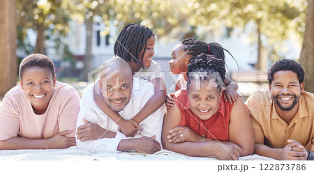 Nature, garden and portrait of a happy black family relaxing together while on summer vacation. Smile, park and positive african people on a picnic outside while on a holiday in the countryside. Nature, garden and portrait of a happy black family relaxing together while on summer vacation. Smile, park and positive african people on a picnic outside while on a holiday in the countryside. 122873786