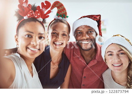 Friends, family and diversity in a Christmas selfie to celebrate the festive season. Black man, women and a happy smile at office xmas party. Team celebration and taking a holiday photo. 122873794
