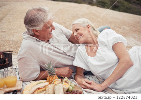 Love, couple and picnic with a senior man and woman on an outdoor date with food and juice in summer. Happy, smile and romance with an elderly male and female enjoying free time together and bonding Love, couple and picnic with a senior man and woman on an outdoor date with food and juice in summer. Happy, smile and romance with an elderly male and female enjoying free time together and bonding 122874023