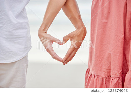 Couple hands, heart and love at beach outdoors for love, care and kindness emoji together. Closeup of happy people save the date relationship, finger shape and affectionate romance of trust marriage 122874048
