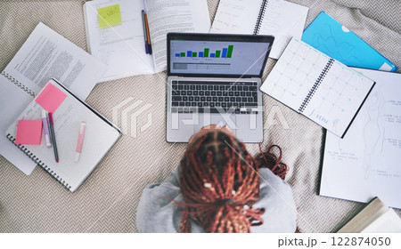 College education and study laptop on bed with school books and sticky notes in home. University student studying graph, analytics and reading digital learning notes for exam preparation. 122874050
