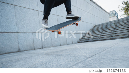 Skateboarder skateboarding in modern city Skateboarder skateboarding in modern city 122874188