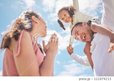 Family, play and love with child on shoulder of father against the blue sky for childhood, bond and care. Happy, summer and freedom with young girl, dad and mom together for joy, fun and youth 122874213