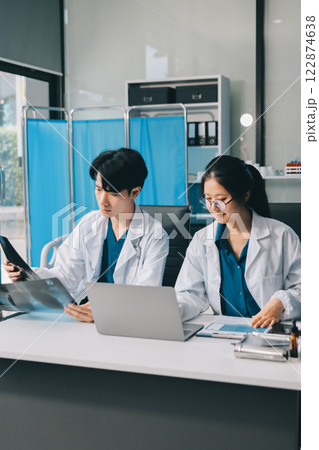 Positive doctor working on laptop in medical office, portrait. 122874638