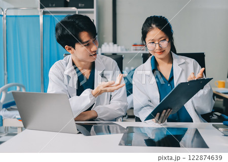 Positive doctor working on laptop in medical office, portrait. 122874639
