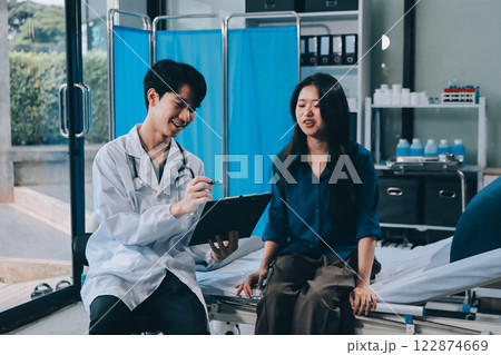 doctor consulting senior old patient filling form at consultation. Professional physician wearing white coat talking to mature woman signing medical paper at appointment visit in clinic. doctor consulting senior old patient filling form at consultation. Professional physician wearing white coat talking to mature woman signing medical paper at appointment visit in clinic. 122874669