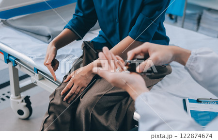 doctor consulting senior old patient filling form at consultation. Professional physician wearing white coat talking to mature woman signing medical paper at appointment visit in clinic. 122874674