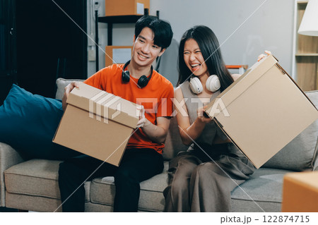 Smiling couple unpacking boxes in new house 122874715