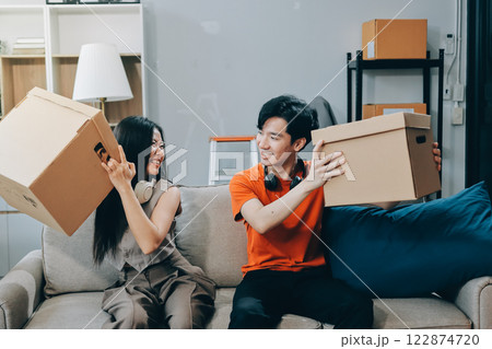 Smiling couple unpacking boxes in new house 122874720