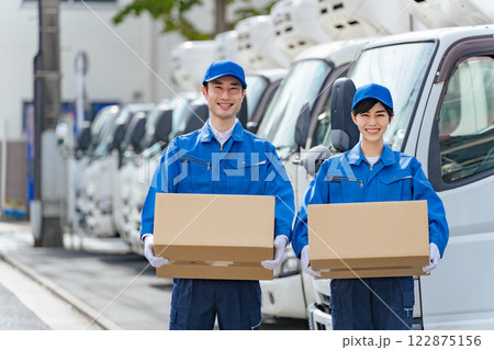 笑顔で荷物を持つ男女配達員　セールスドライバー　運送業者 122875156