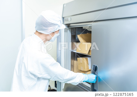 冷蔵庫に入った食品を管理する白衣の男性調理スタッフ 冷蔵庫に入った食品を管理する白衣の男性調理スタッフ 122875165