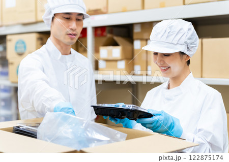 倉庫で食品を箱詰めする白衣の女性 給食センター 宅配食 包装工場 倉庫で食品を箱詰めする白衣の女性 給食センター 宅配食 包装工場 122875174