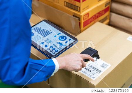 ハンディスキャナとタブレットで荷物の情報を管理する作業員 122875196