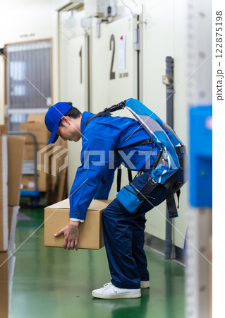 倉庫でパワーアシストスーツを使う作業員 倉庫でパワーアシストスーツを使う作業員 122875198