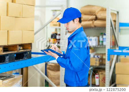 タブレットで倉庫を管理する男性スタッフ 122875200